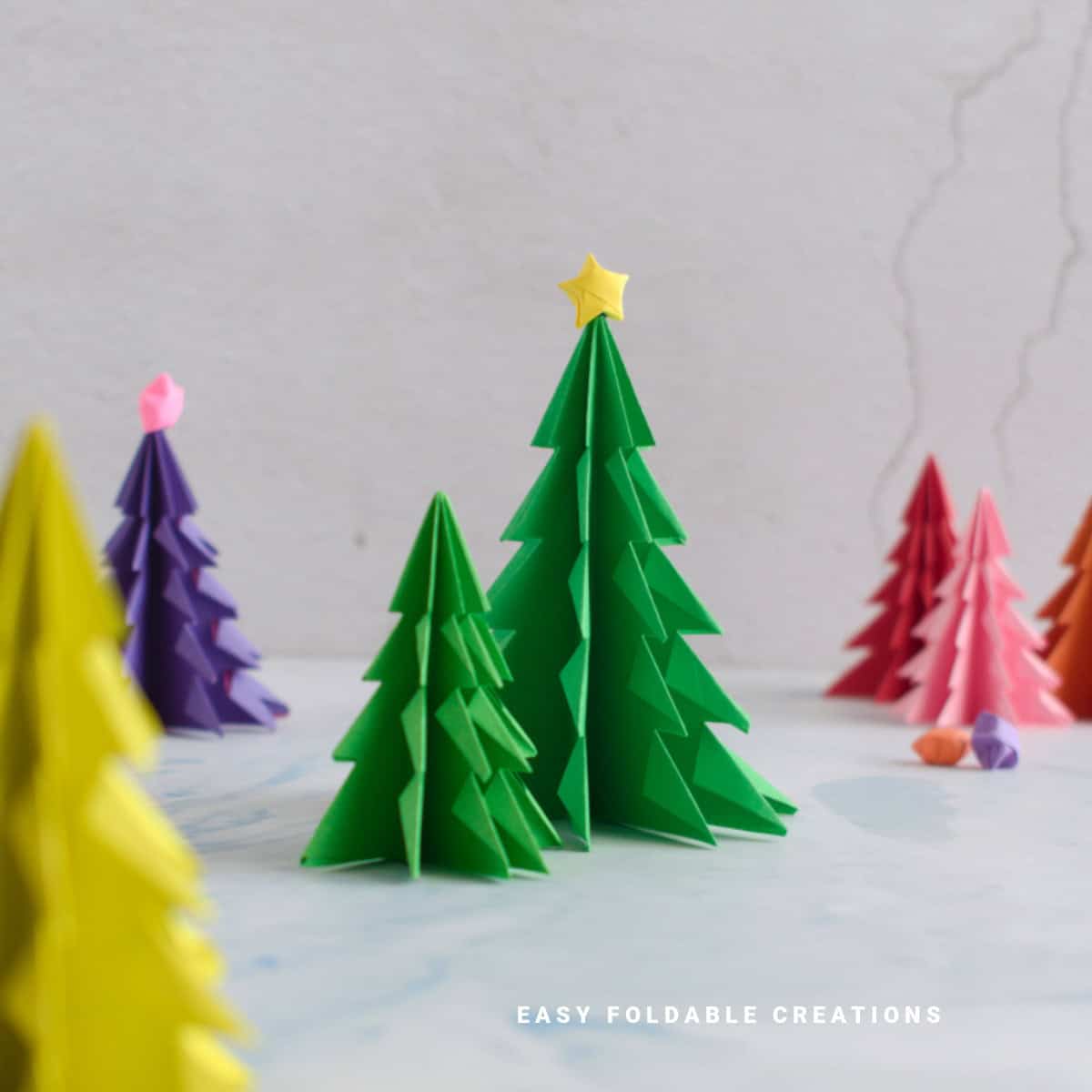 Close up image of two green origami Christmas trees.