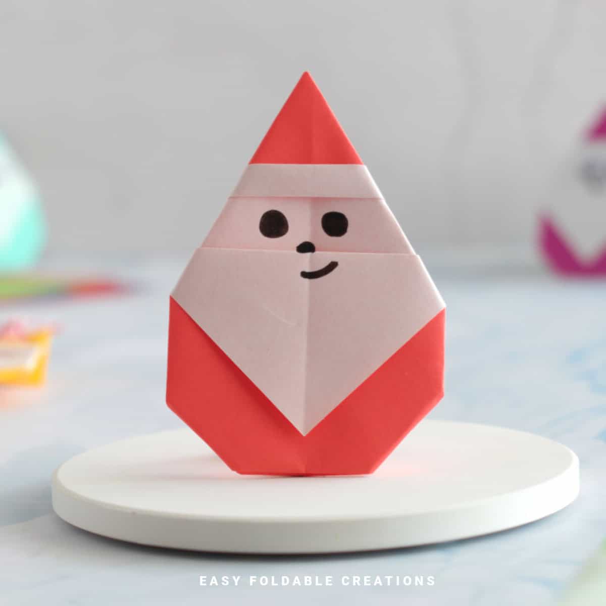 Close up image of a red and white origami Santa.