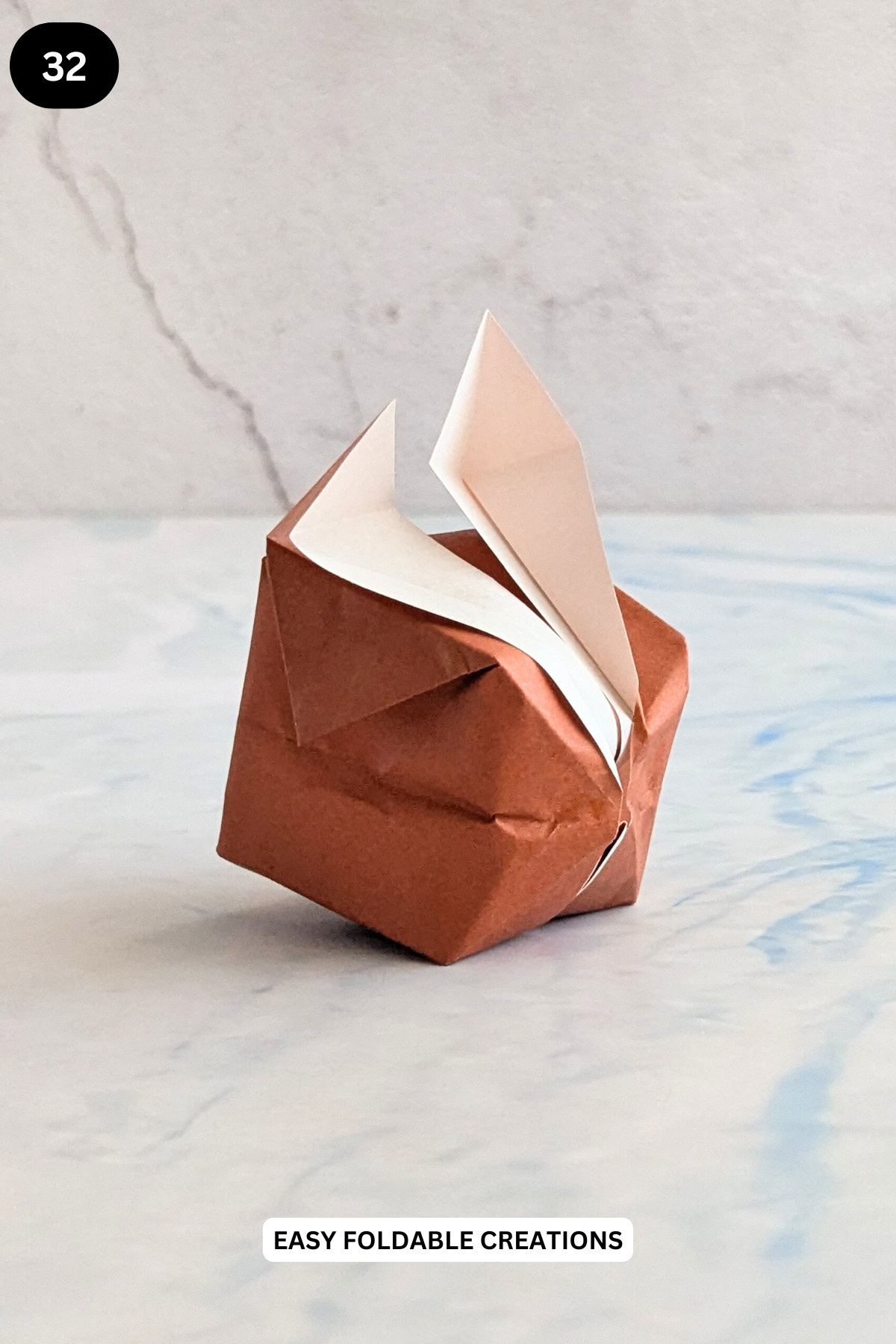 Step 32 for folding an inflatable origami rabbit.