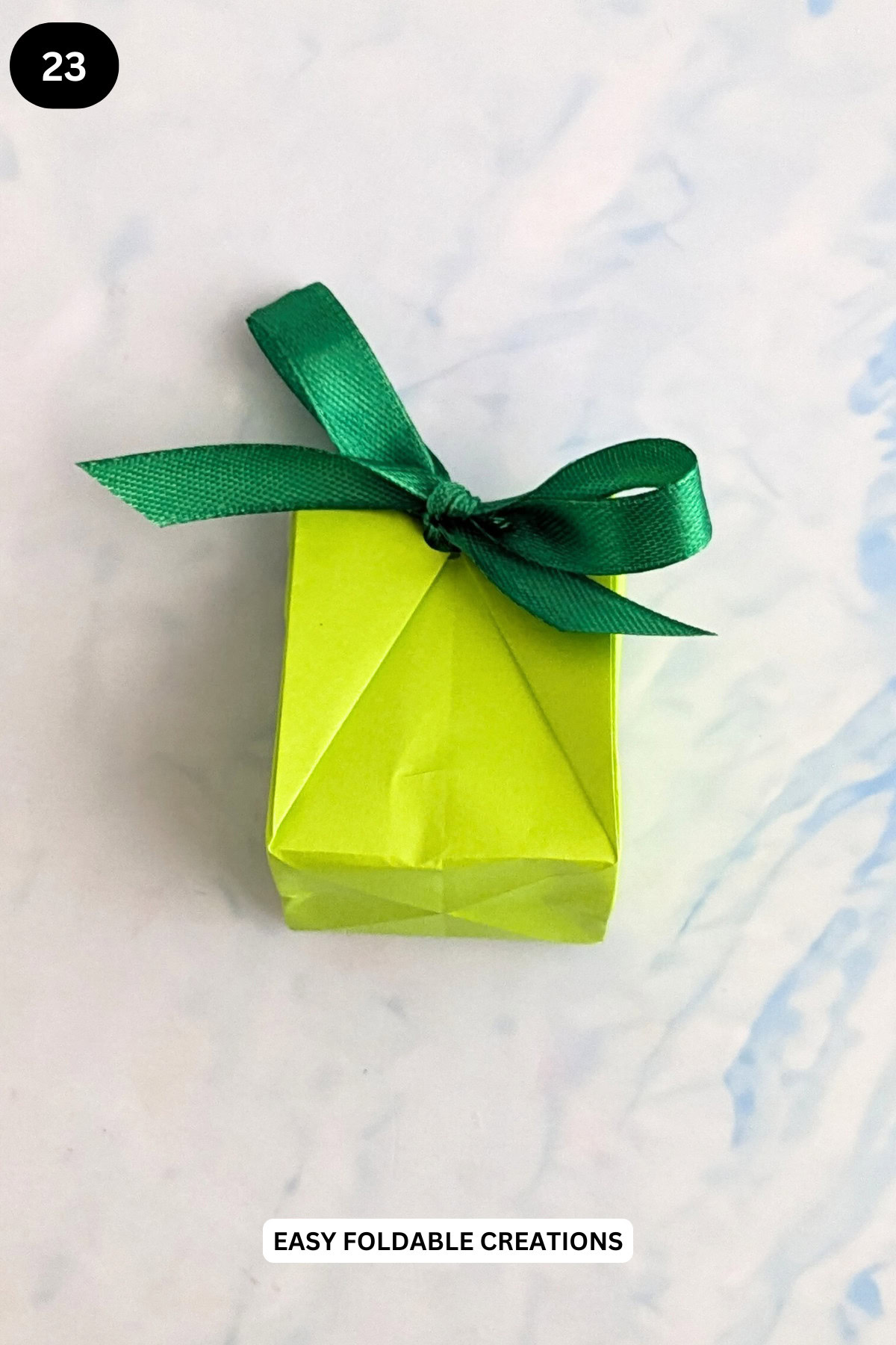 Step 23 for folding a pleated DIY paper gift bag.