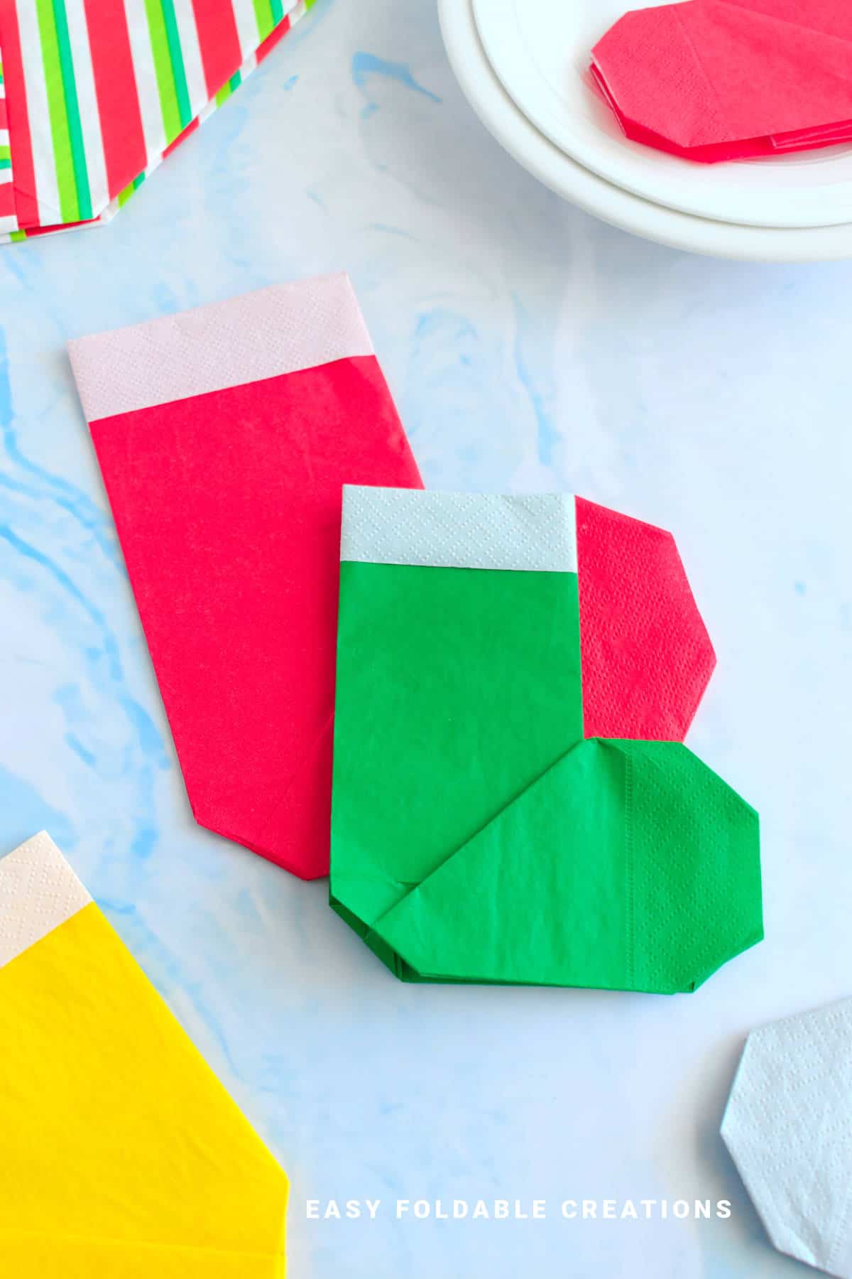 Red and green Christmas stocking napkin folds.