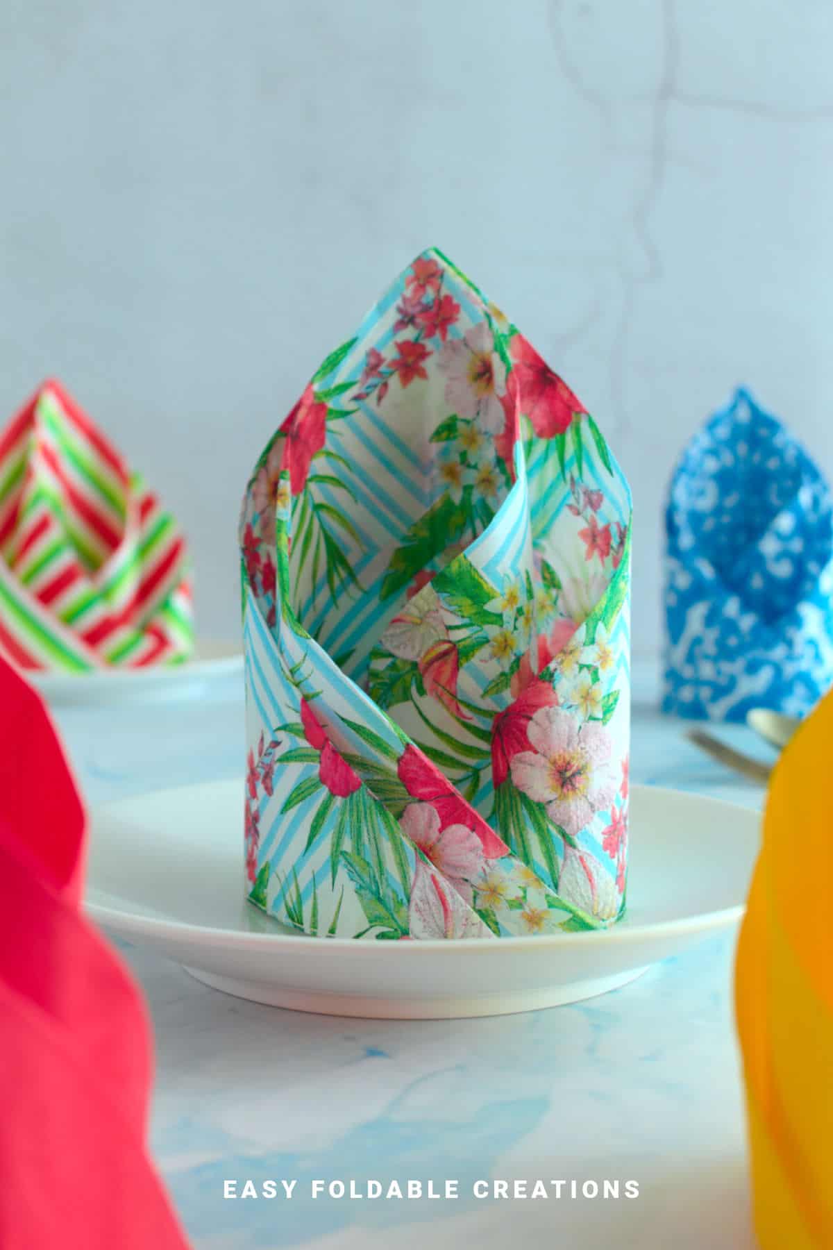 Spiral napkin fold on a plate.