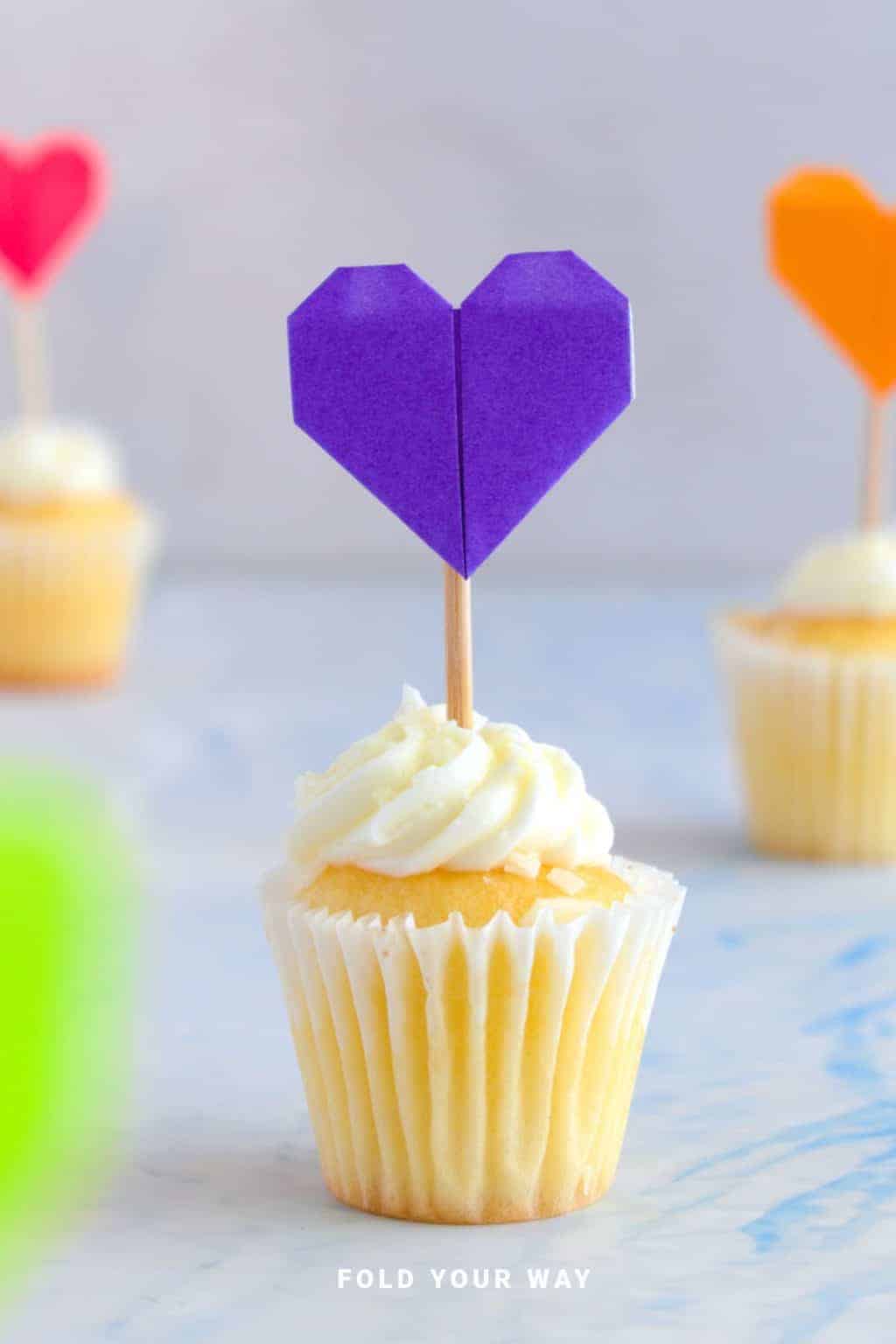 Paper heart cake topper on a cupcake.